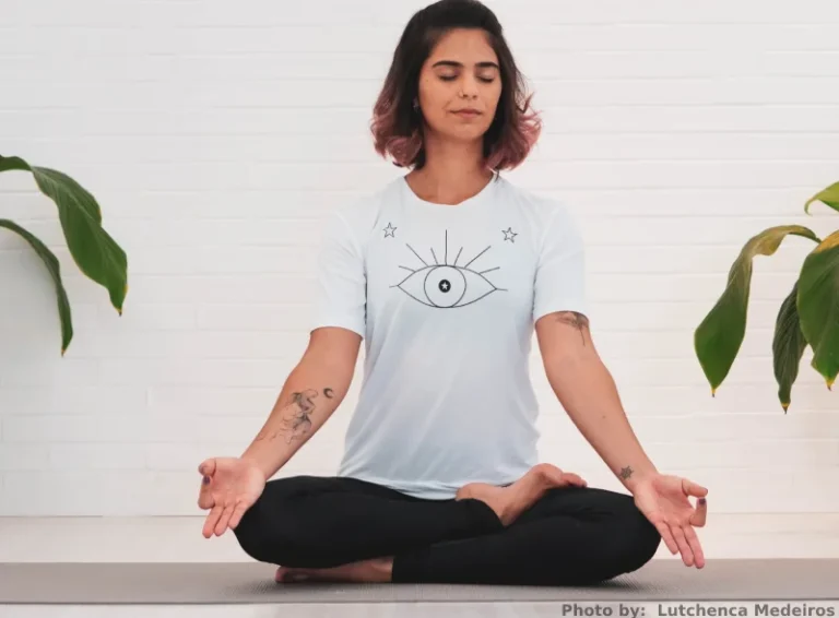 Person sitting crossed legged meditating. practicing manifestation techniques.