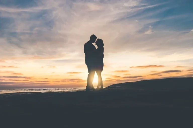 A couple hugging in silhouette with a sunset behind them. Manifesting love with a specific person.