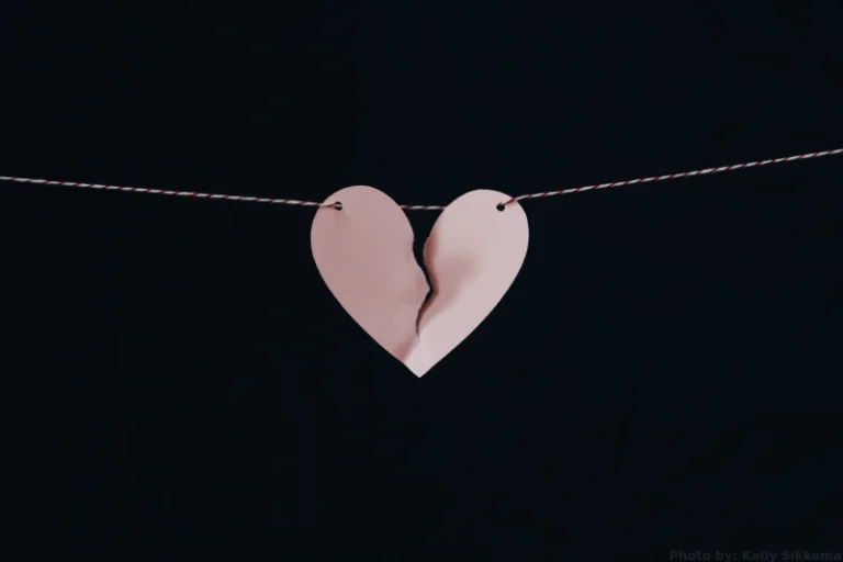 A pink paper heart ripped down the middle hanging on a string. How to manifest a breakup