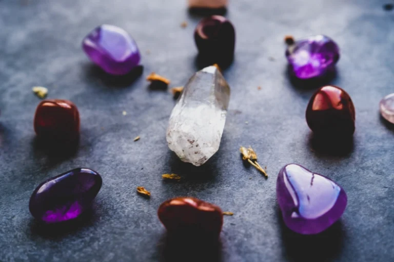 A white love crystal surrounded by 8 purple and red crystals. Best crystals for manifesting love.