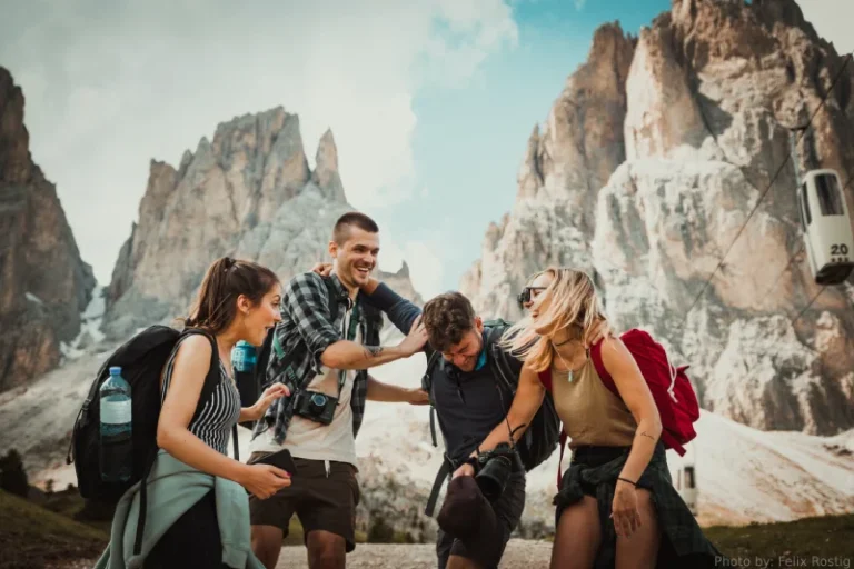 A group of friends laughing while backpacking on a mountain. How to manifest popularity.